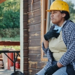 Строитель отдыхает после рабочего дня с планшетом в руках