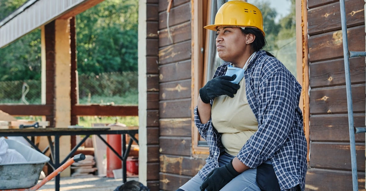 Строитель отдыхает после рабочего дня с планшетом в руках